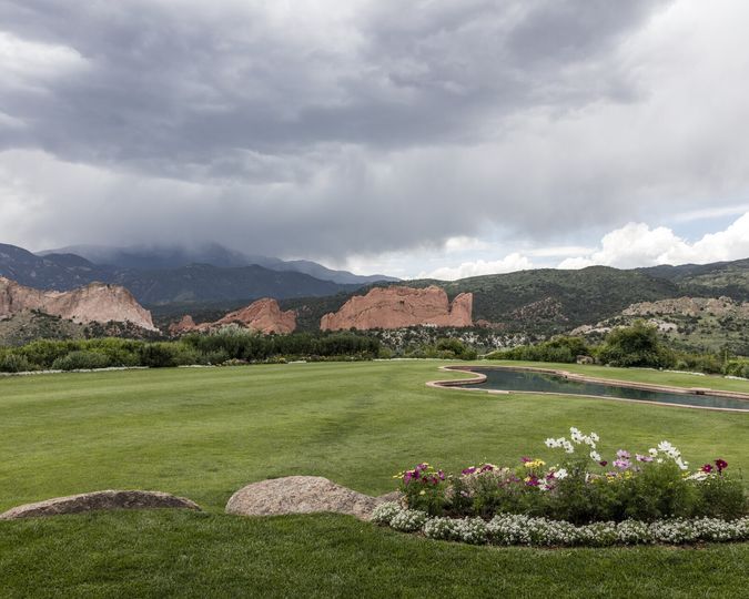 Red rock formations of Garden of the Gods beyond a green lawn in Colorado Springs