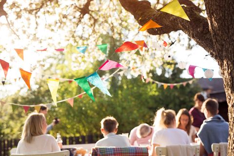 Guests seated outdoors under strings of colorful bunting
