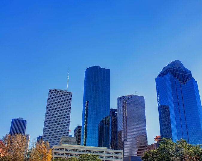 Glass towers of the downtown Houston skyline under a blue sky