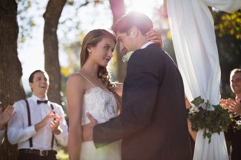 Bride and groom embracing at an outdoor ceremony